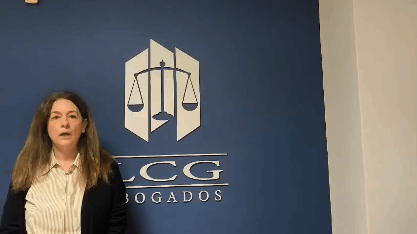 Inmaculada Lax Muñoz en su despacho, delante del logo de LCG Abogados